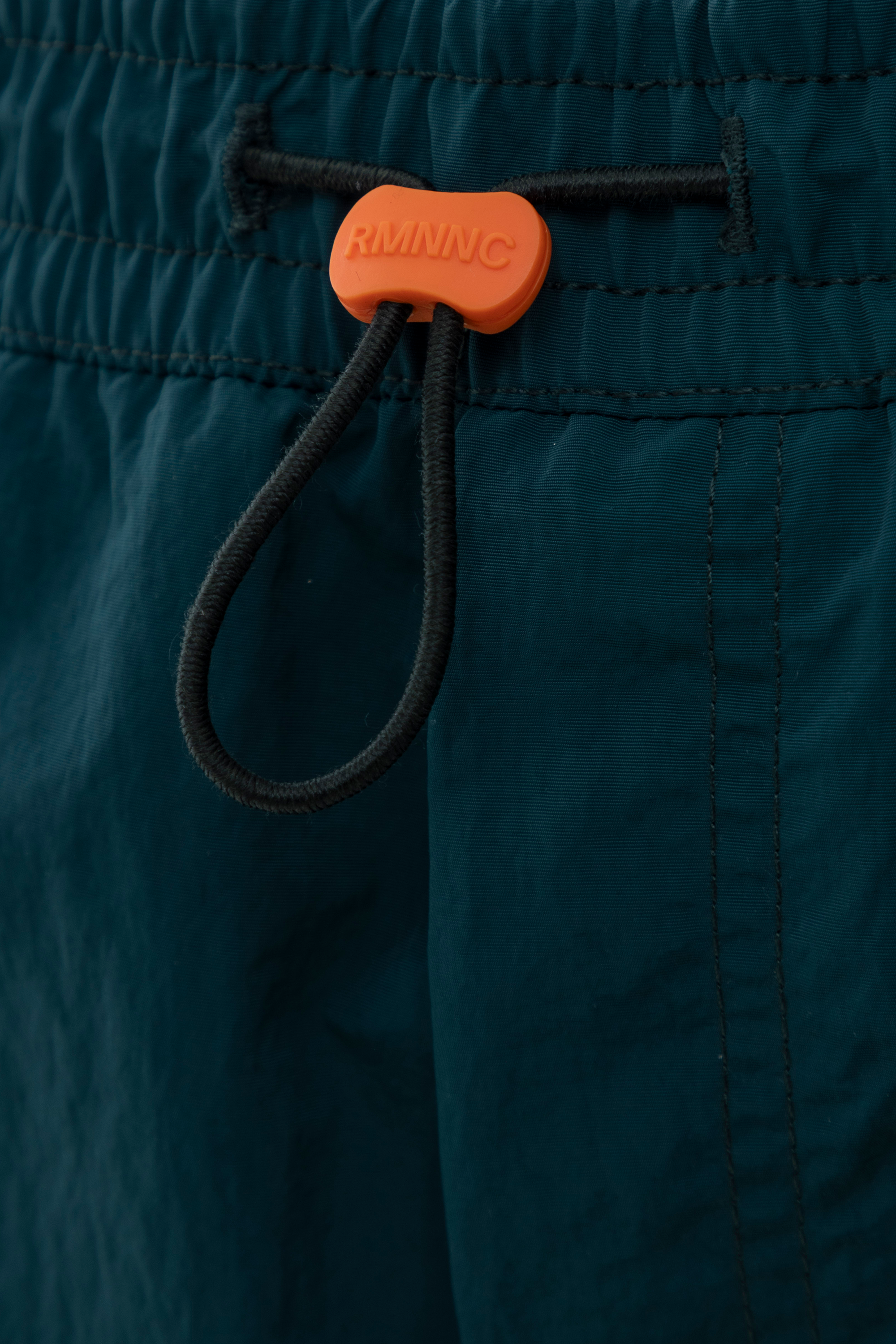 Detalle de tensor naranja sobre pretina elástica.