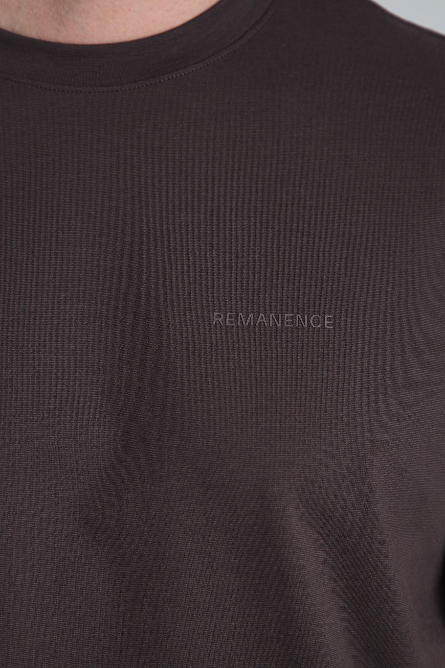 detalle logo Remanence en camiseta café para hombre Peak