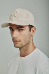 Gorra color arena con visera curva y logo bordado, estilo minimalista ideal para complementar looks neutros