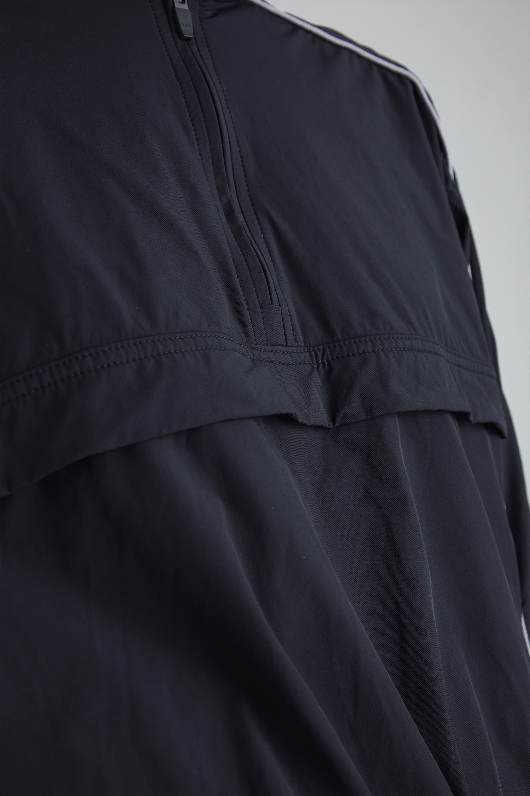 Detalle half zipper de la chaqueta negra para mujer