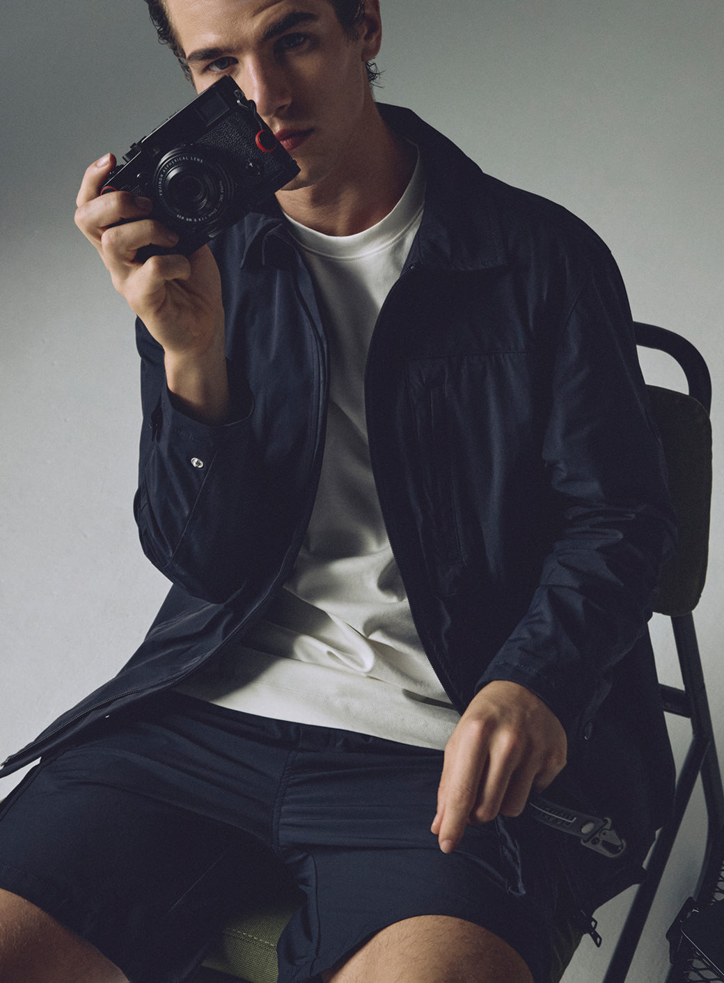 Modelo con camiseta blanca, chaqueta negra cuello camisa y short negro Remanence.