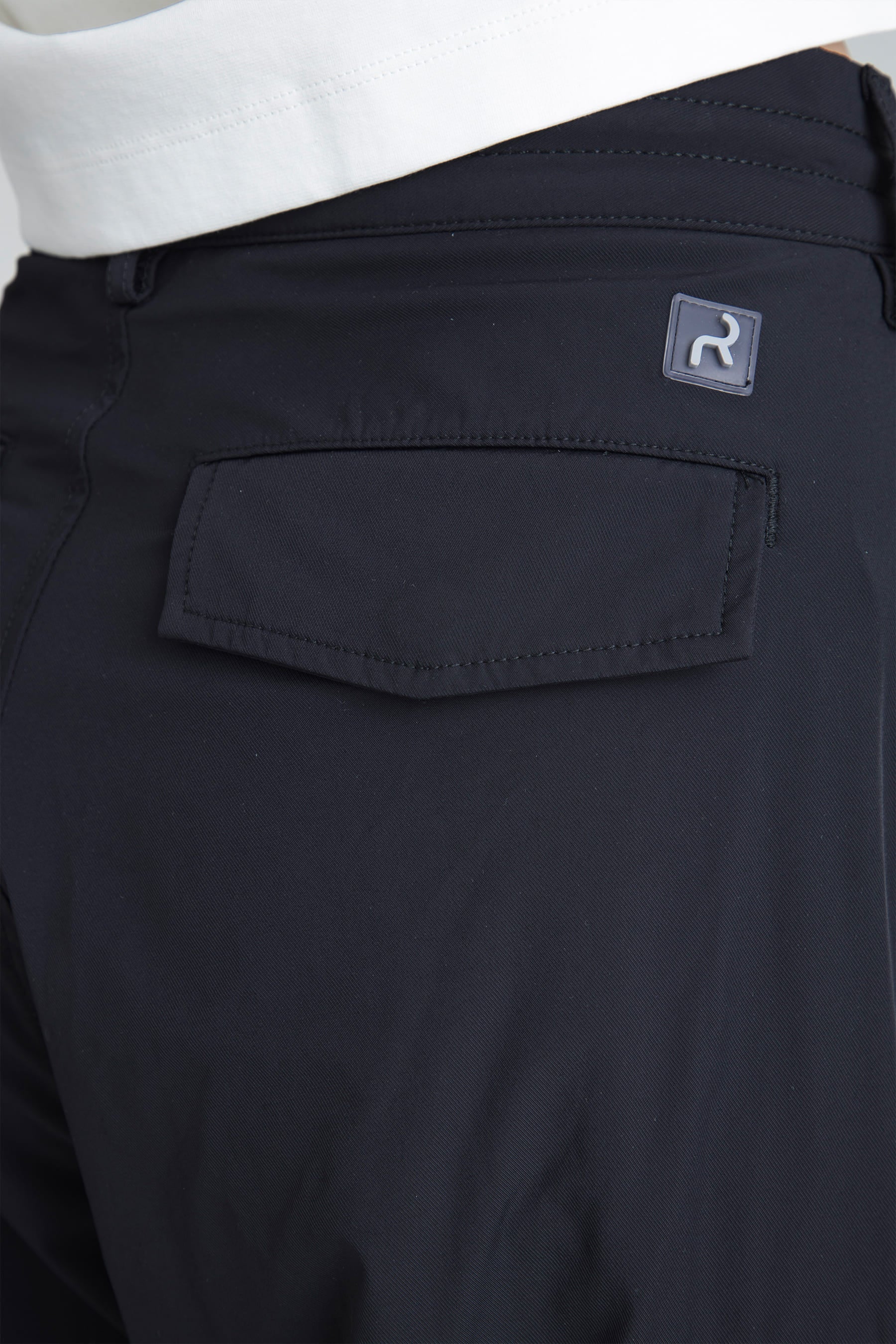 Detalle bolsillo posterior y logo en el pantalón parachute negro para mujer