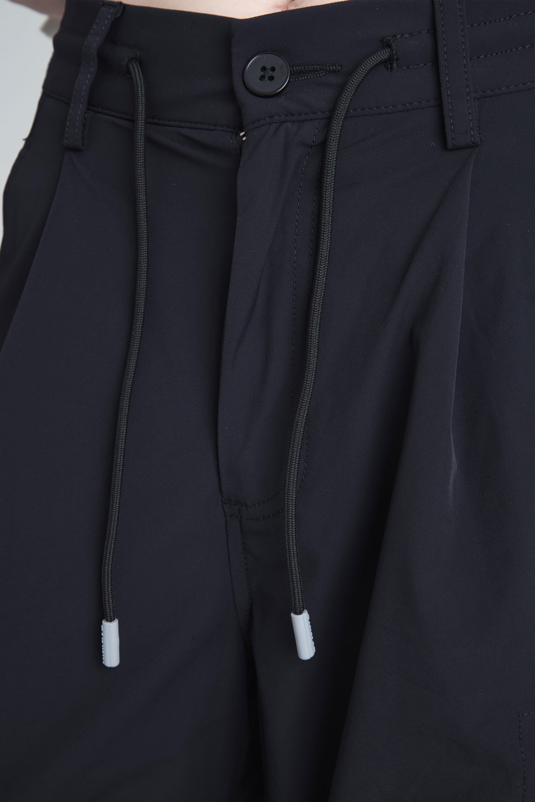 Detalle pretina con cordón en el pantalón parachute negro para mujer