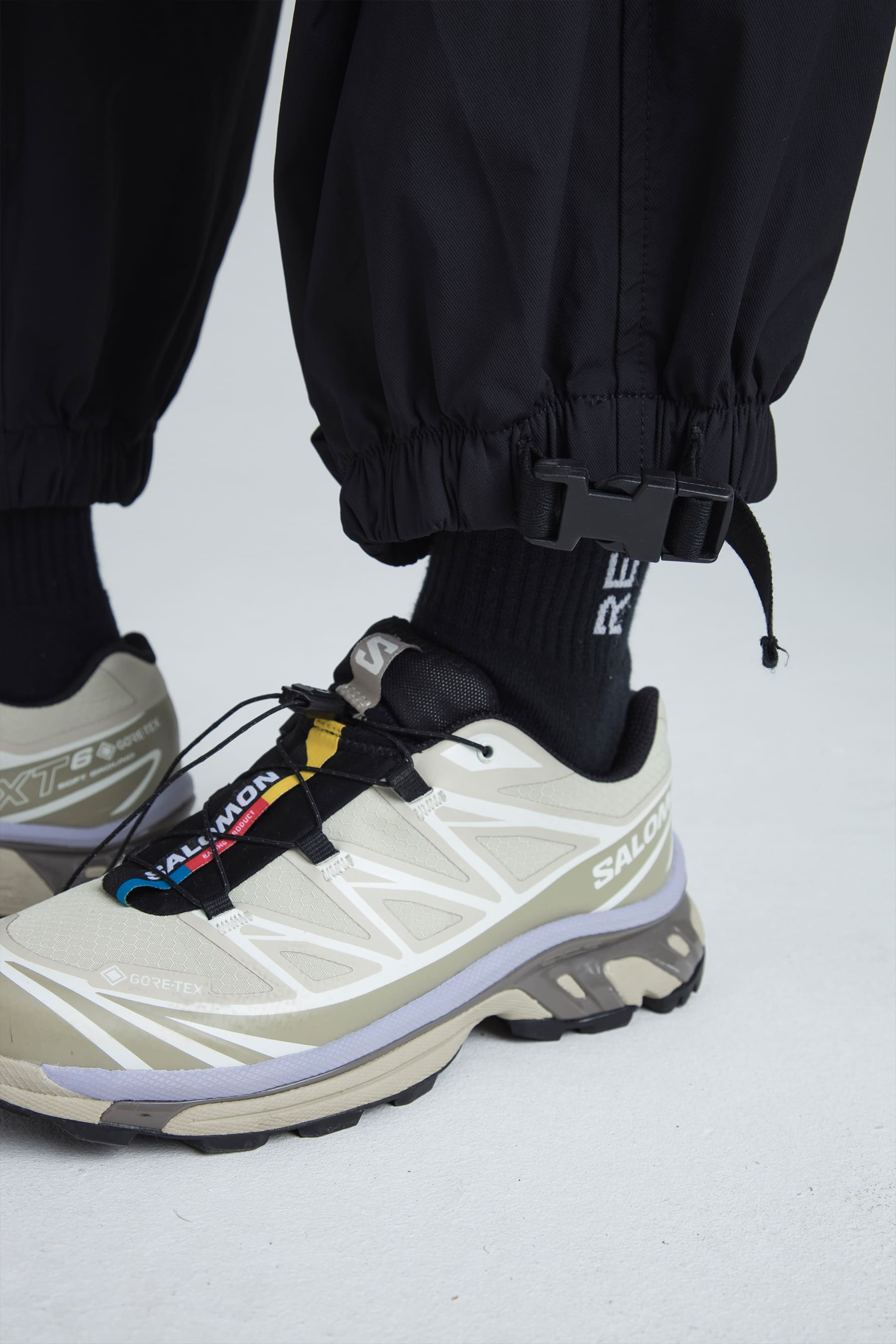 Detalle ajuste en bota en el pantalón parachute negro para mujer