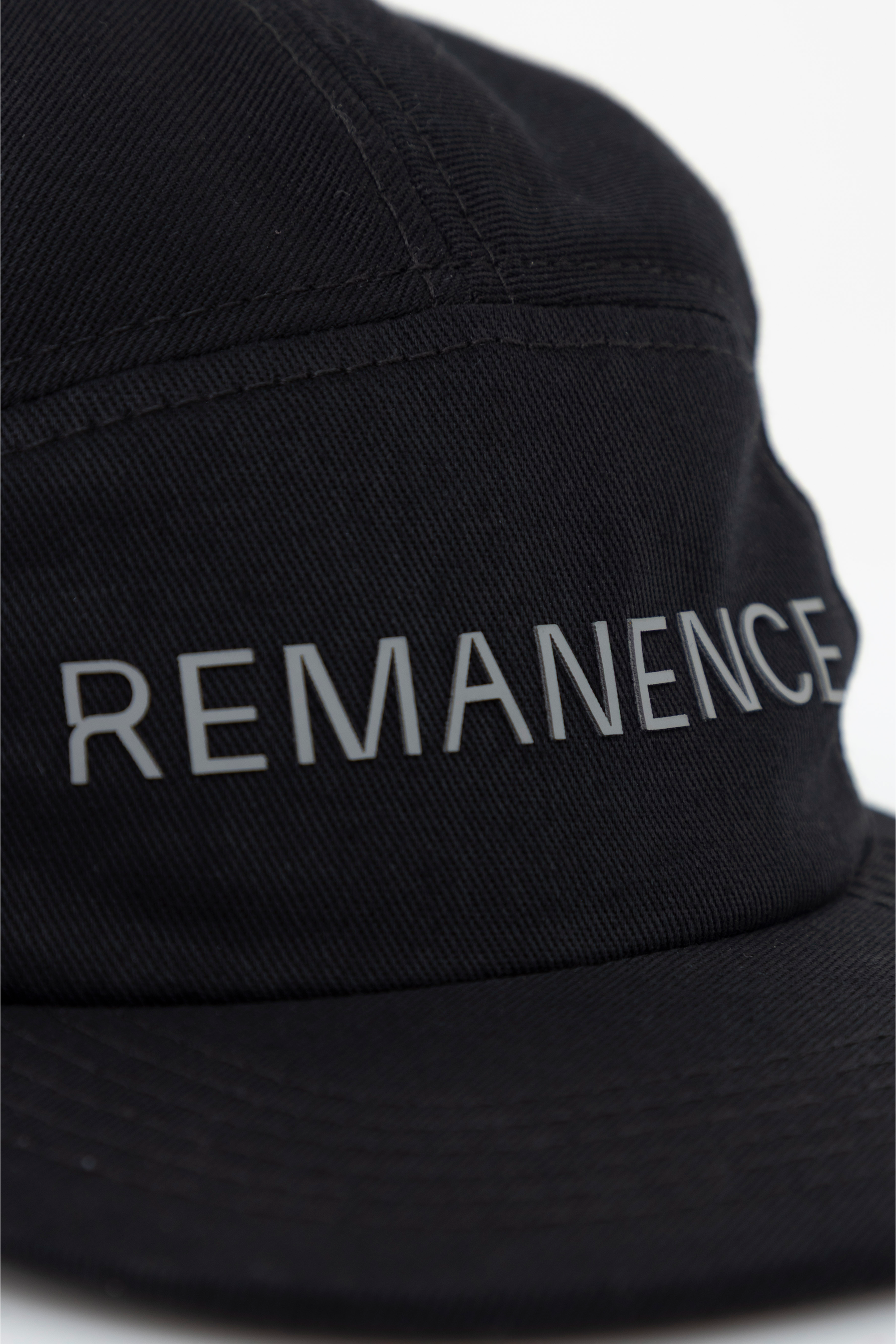 Acercamiento al logo Remanence estampado en alta densidad sobre la parte frontal.