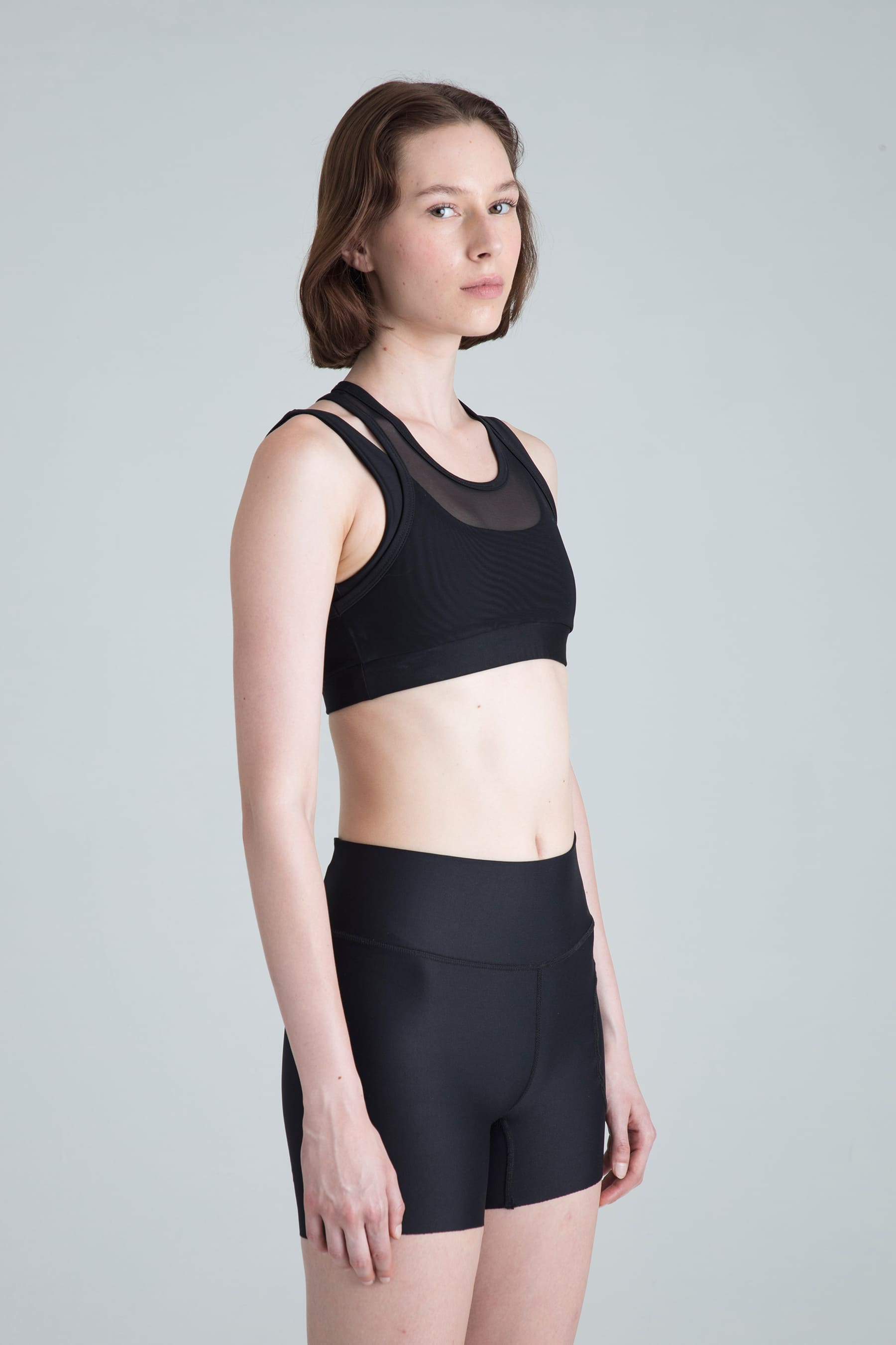Top deportivo negro para mujer Apex perfil lateral en modelo