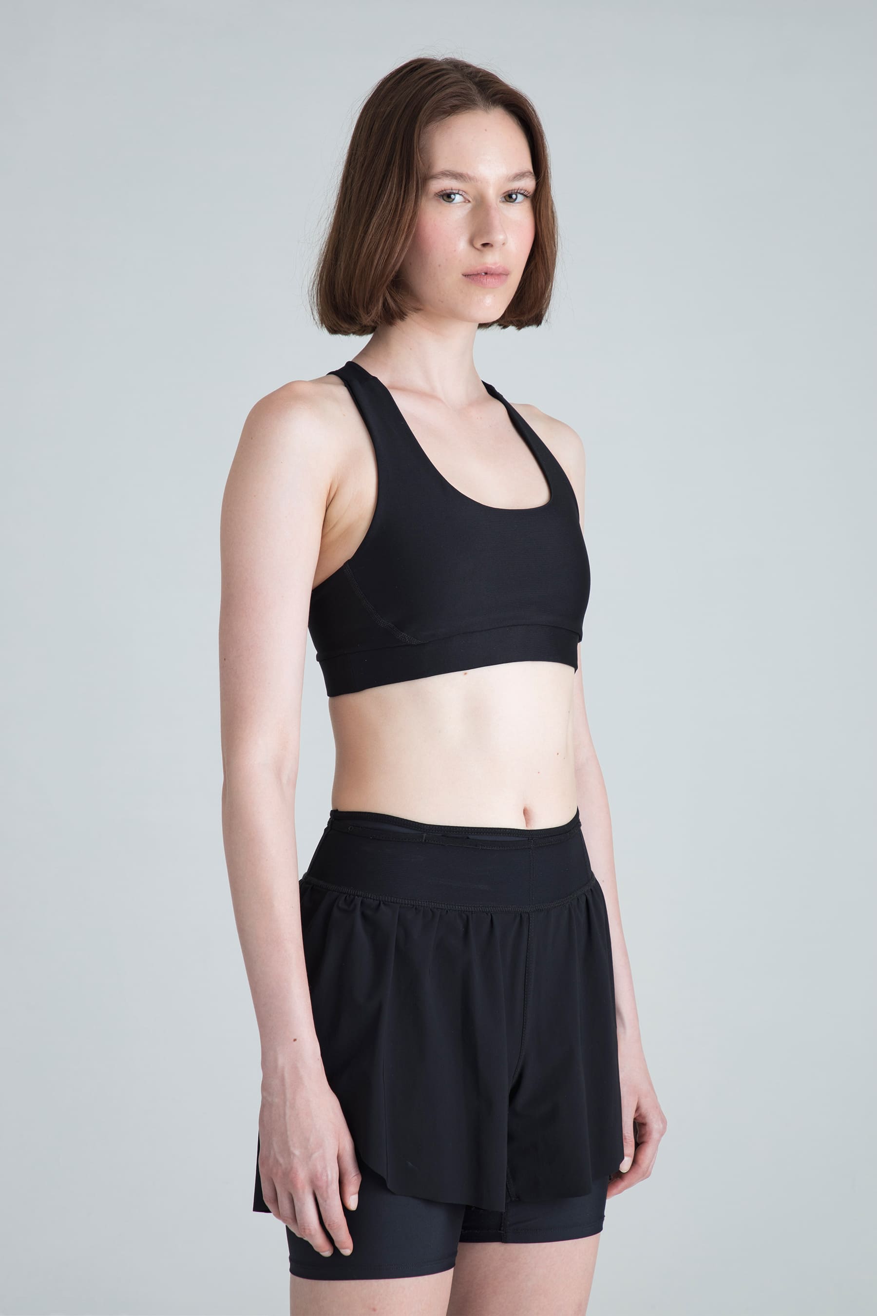 Top deportivo negro para mujer Motion perfil lateral en modelo