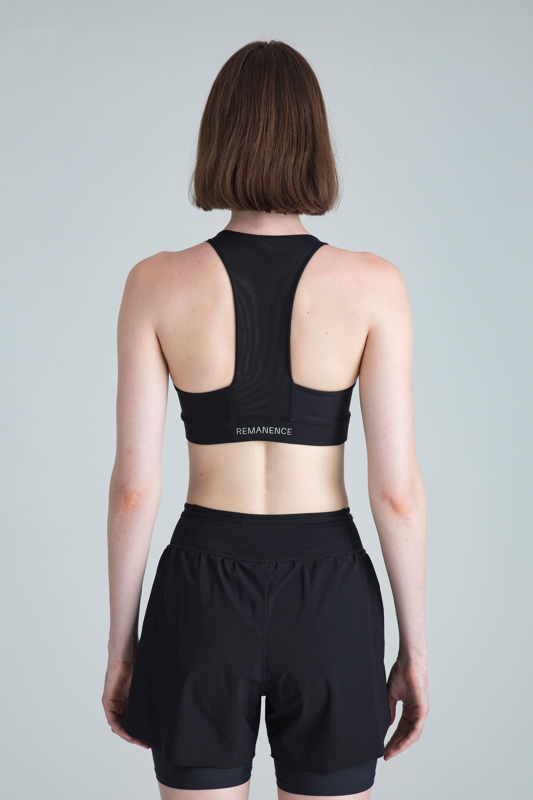 Top deportivo negro para mujer Motion vista posterior con mesh