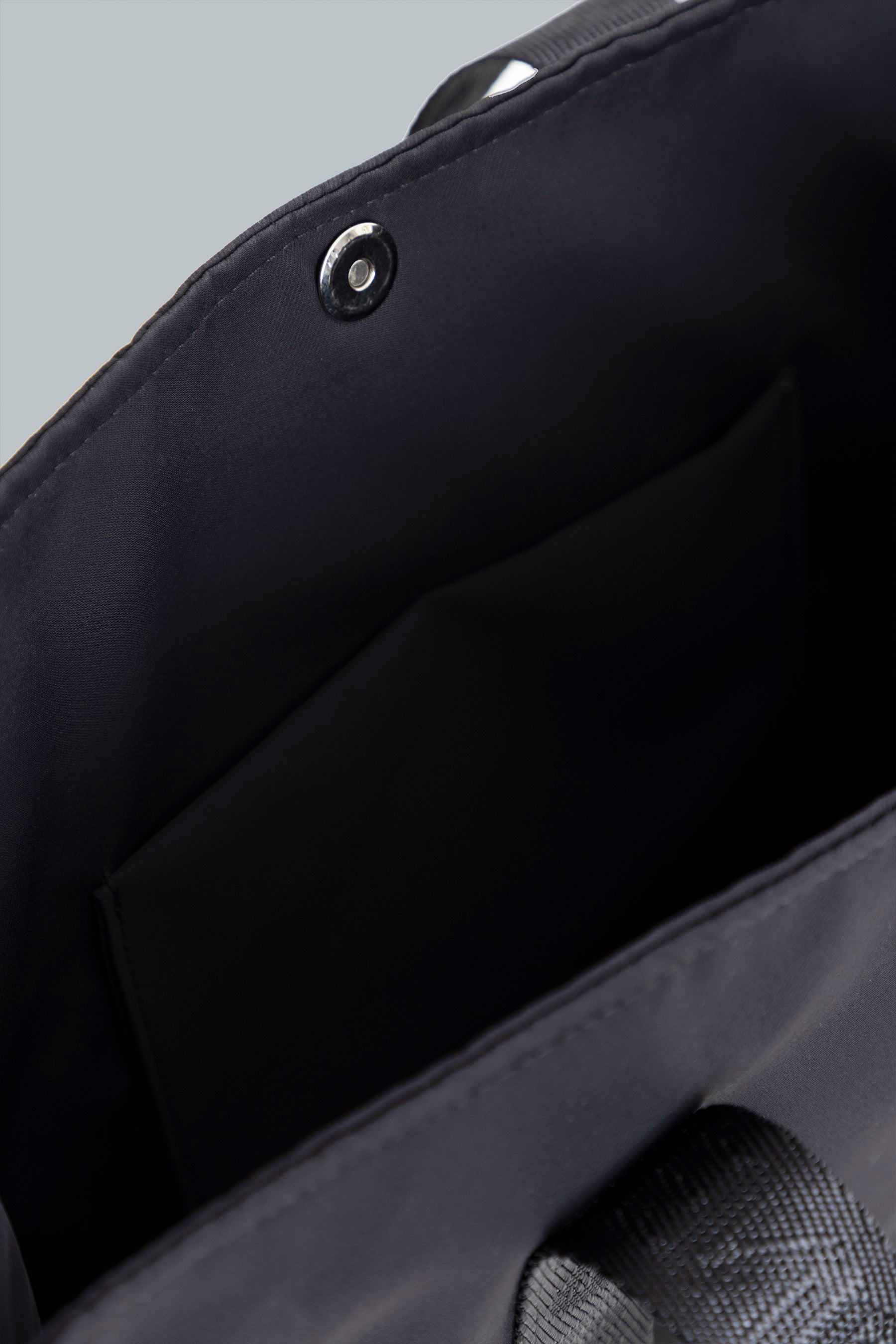 Interior del bolso tote negro con cierre y compartimentos