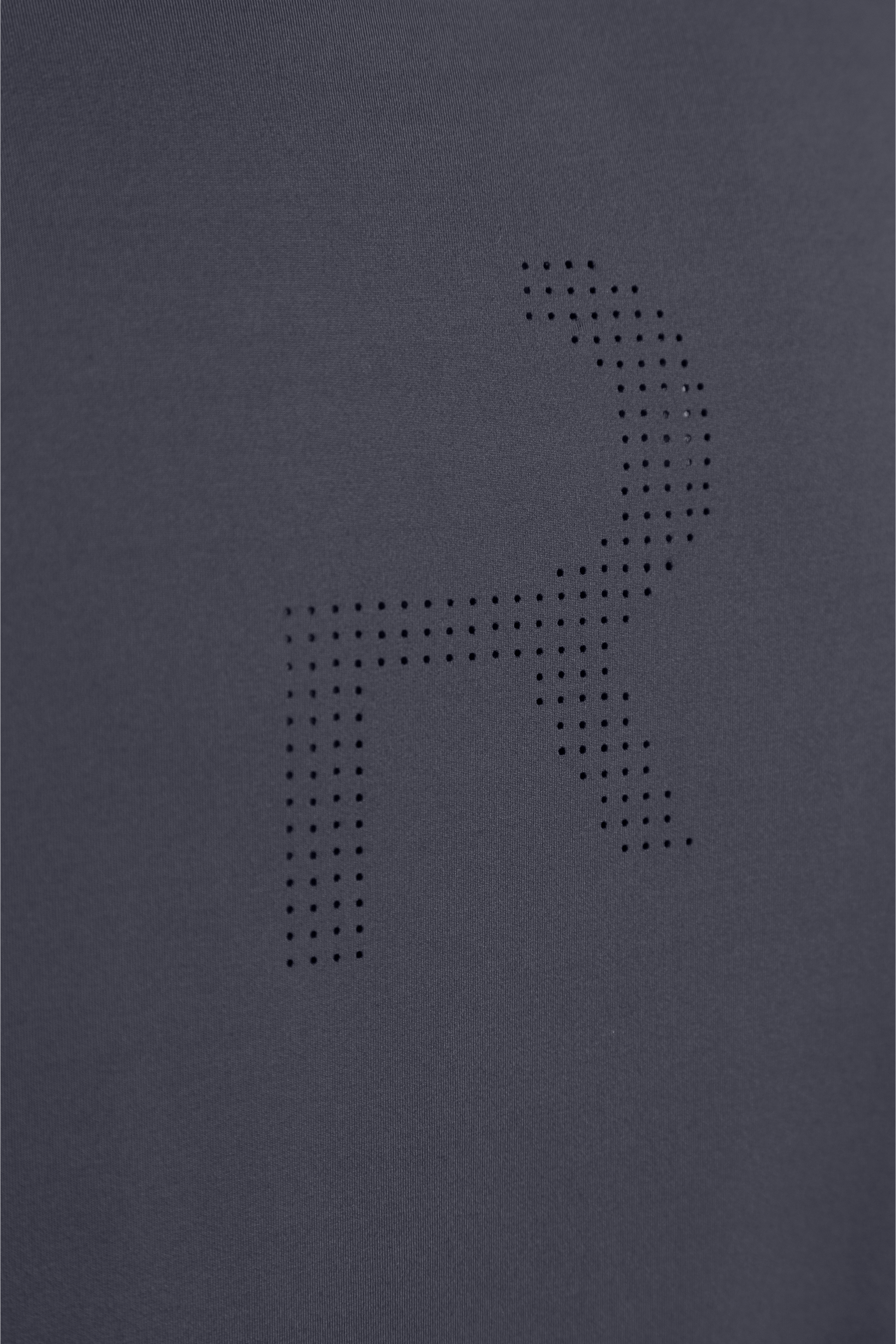 Detalle del logo perforado en la espalda para ventilación estratégica.